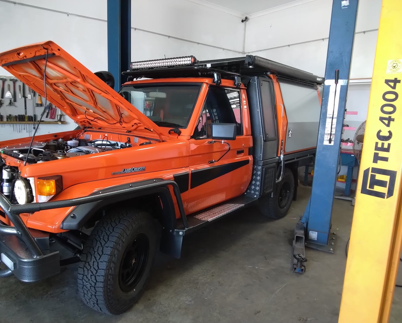 Orange four-wheel-drive vehicle with its bonnet open inside the Autochill workshop