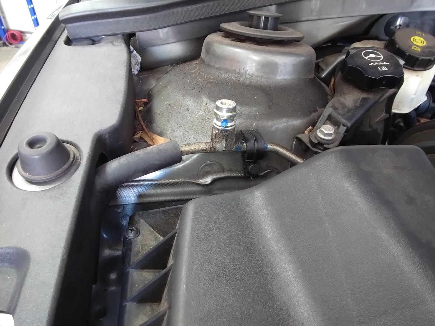 Automotive air-conditioning service connection inside an engine bay